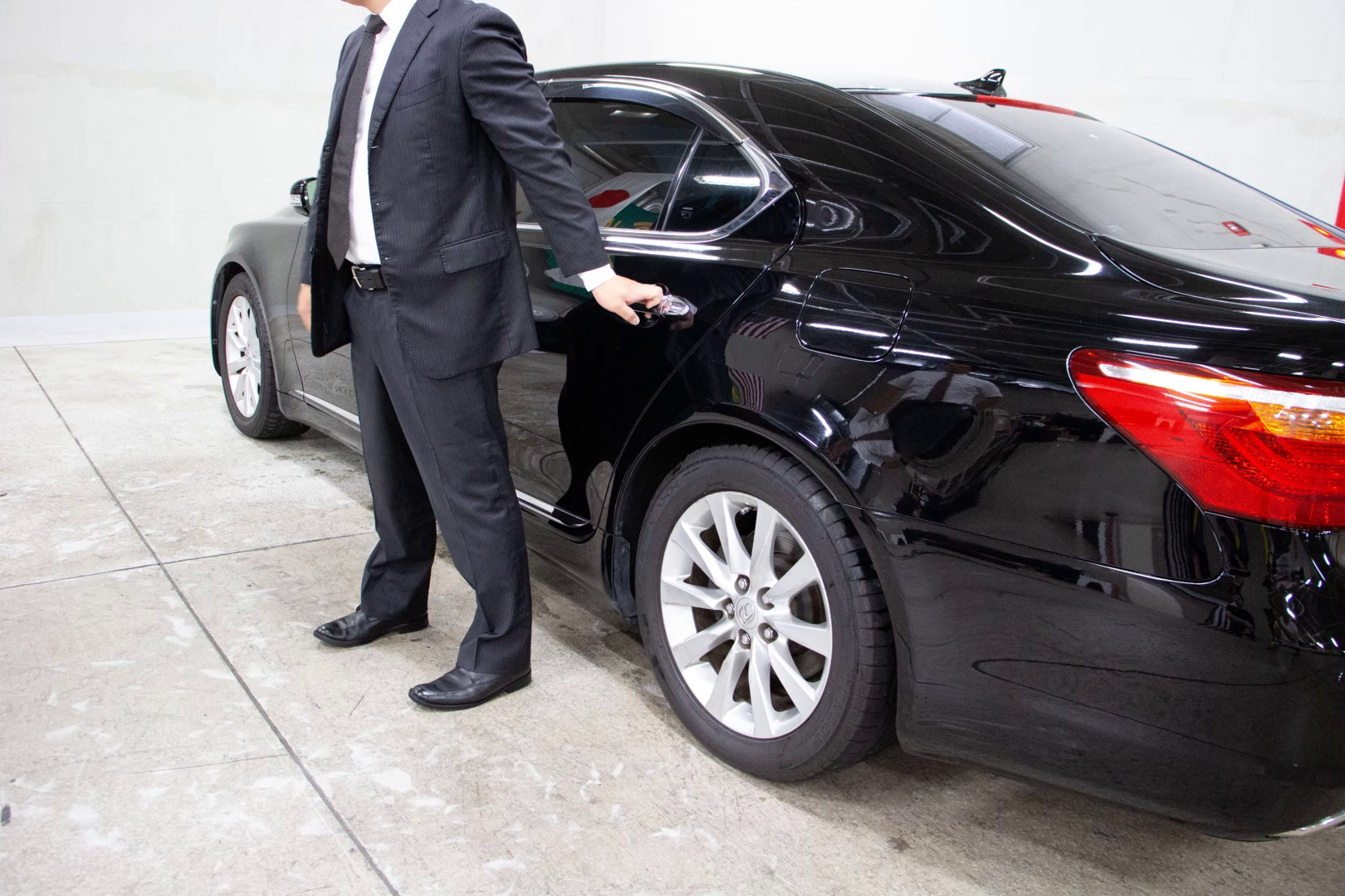 Security officer standing by a rear passenger door