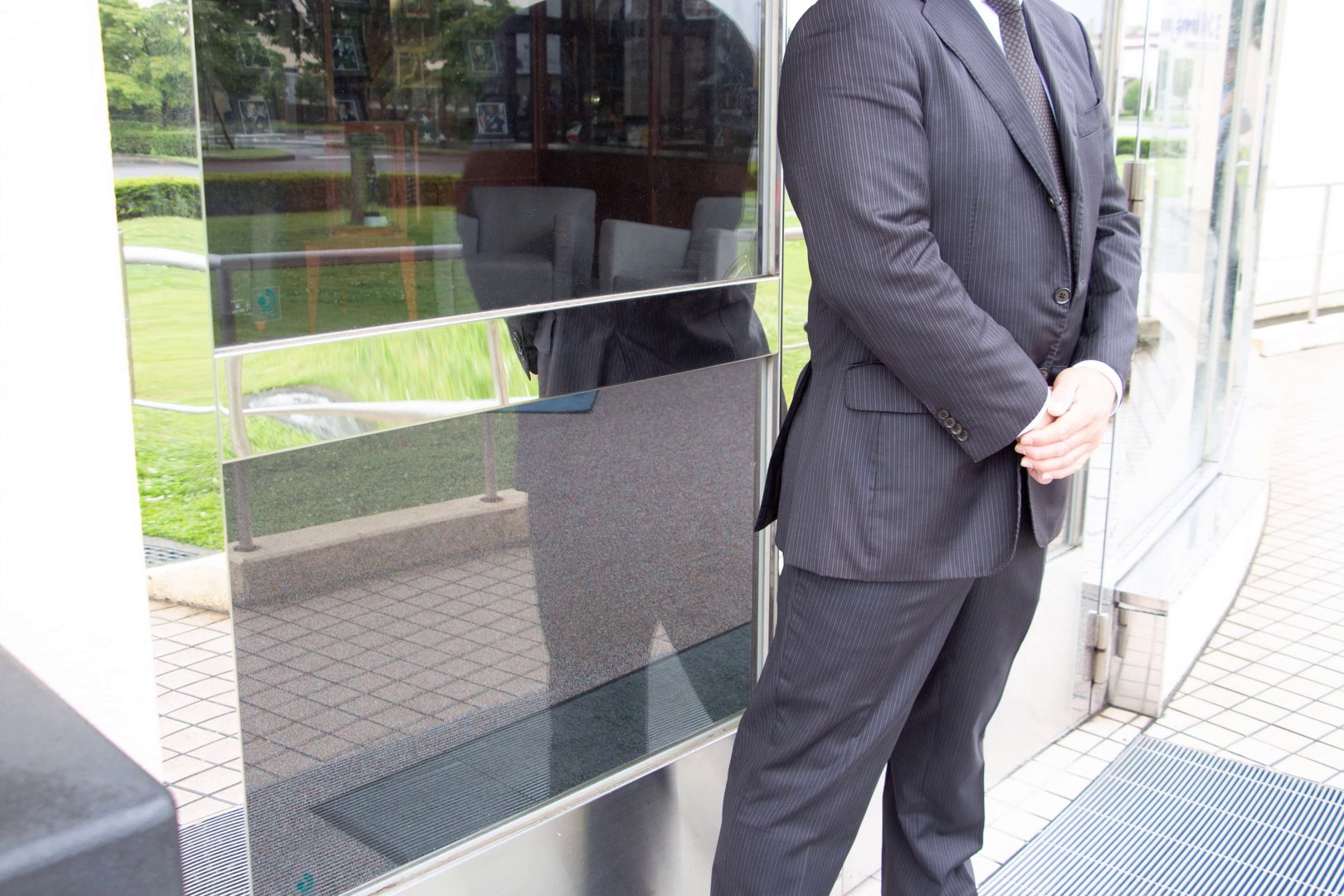 Suited security officer standing at a glass entrance