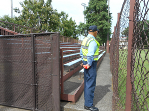 A Zone security officer beside outdoor seating and a perimeter fence