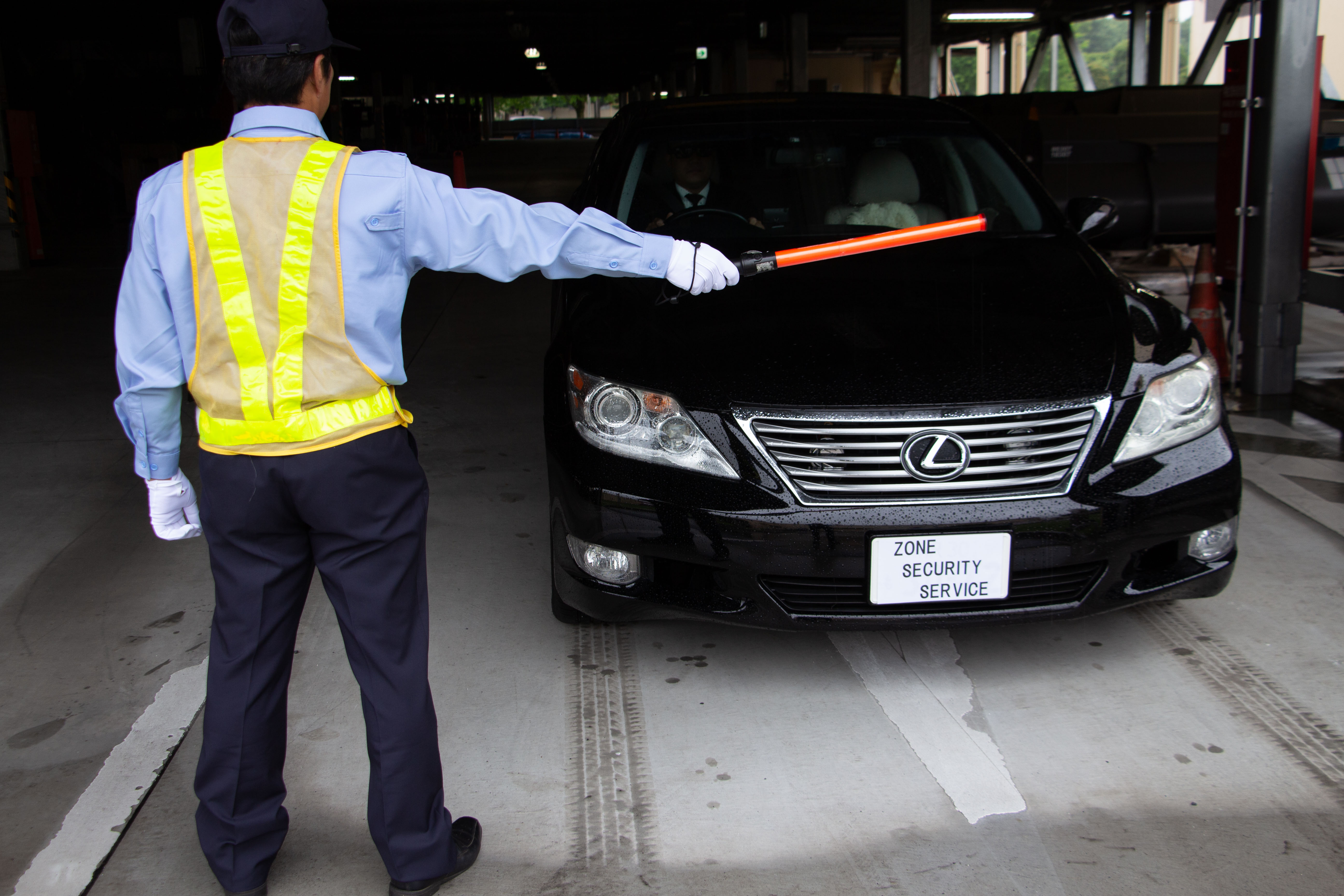 Zone officer guiding a vehicle with a traffic baton